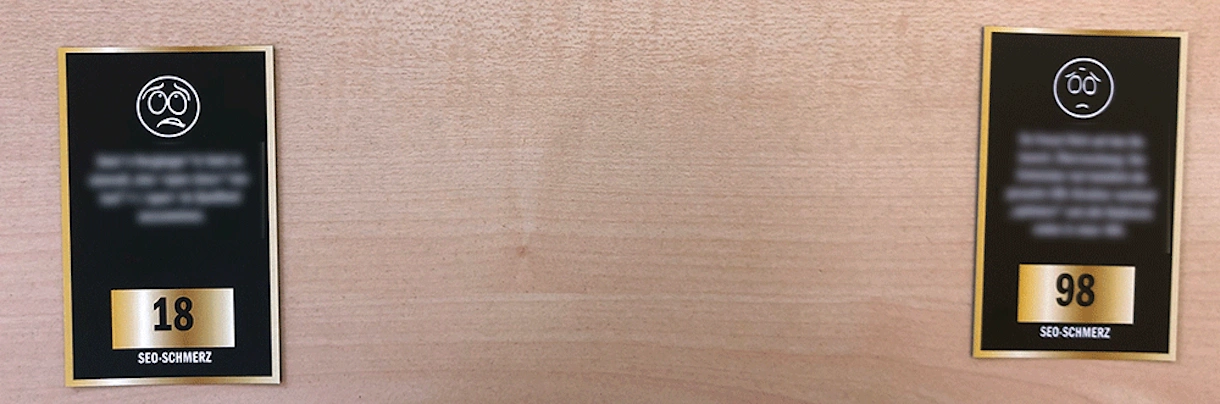 Zwei schwarze Tafeln mit weißen, traurigen Gesichtern und Zahlen 18 und 98, darunter der Text 'SEO-SCHMERZ'.