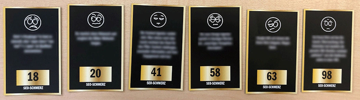 Sechs schwarz-weiße Karten mit verschiedenen Gesichtsausdrücken und Zahlen, darunter 18, 20, 41, 58, 63 und 98, jeweils mit der Bezeichnung 'SEO-SCHMERZ'.