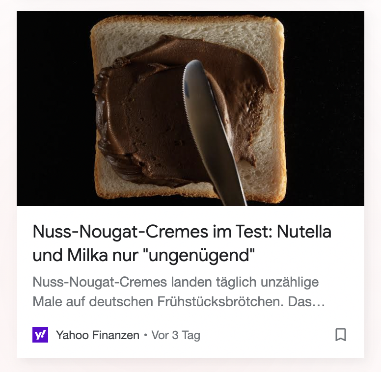 Google-Discover-Karte von Yahoo Finanzen mit einem dunklen Foto von Toast mit Schokoaufstrich und der Überschrift „Nuss-Nougat-Cremes im Test: Nutella und Milka nur ungenügend“.