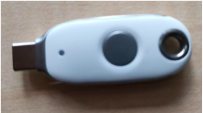 Titan Security Key Ein weißer USB-Sicherheitsschlüssel mit runder Taste und einer Öse für den Schlüsselbund, wie er für die Anmeldung nach dem FIDO2-Standard benutzt wird.