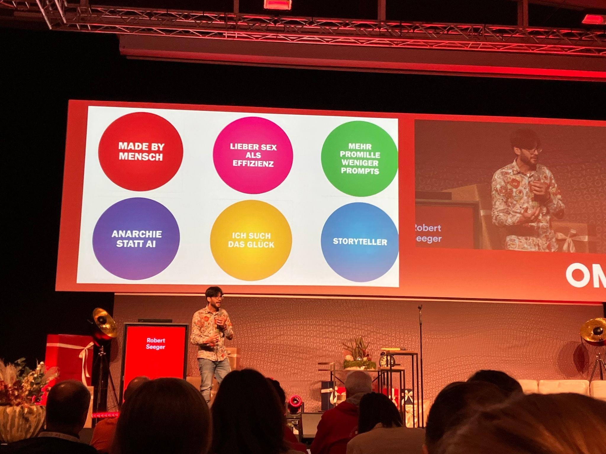 Paul Seeger bei seiner Keynote auf der OMX 2023 in Salzburg.
"Made by Mensch, Lieber Sex als Effizienz, Mehr Promille, weniger Prompts, Anarchie statt AI, Ich such das Glück, Storyteller"